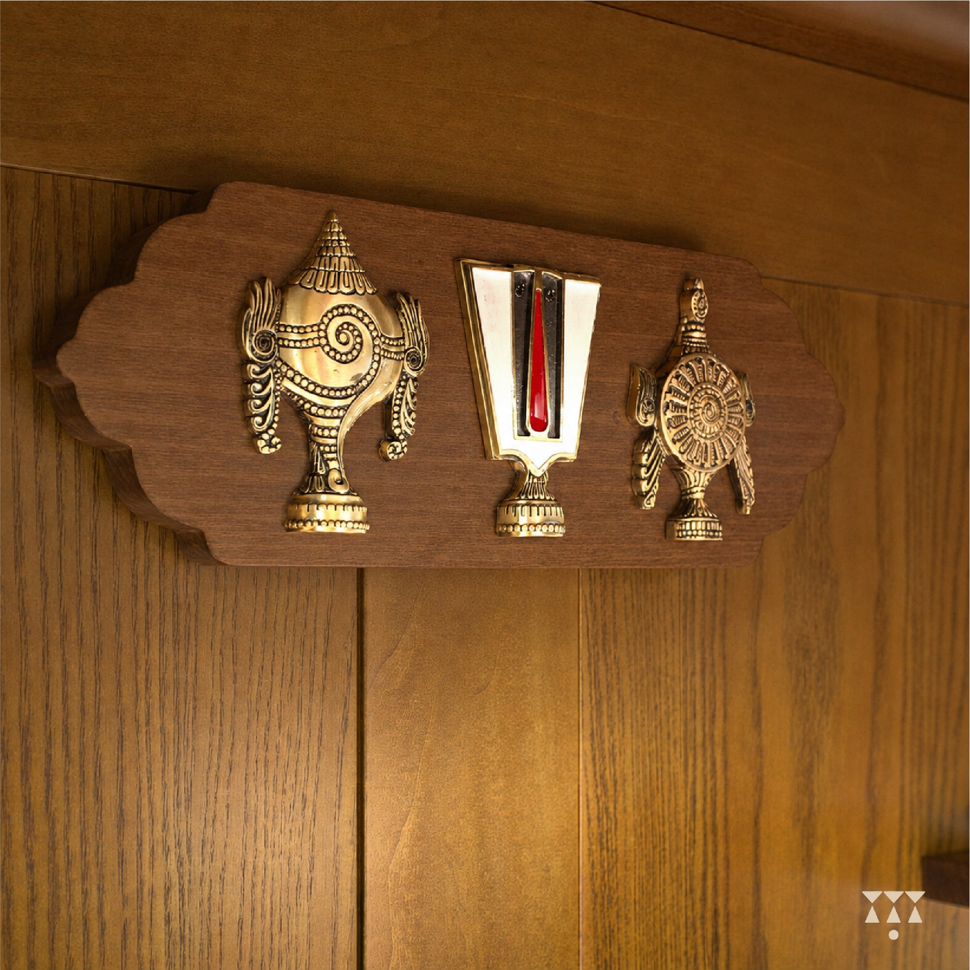 Decorative wooden panel with brass Shank chakra namaha on a wooden background