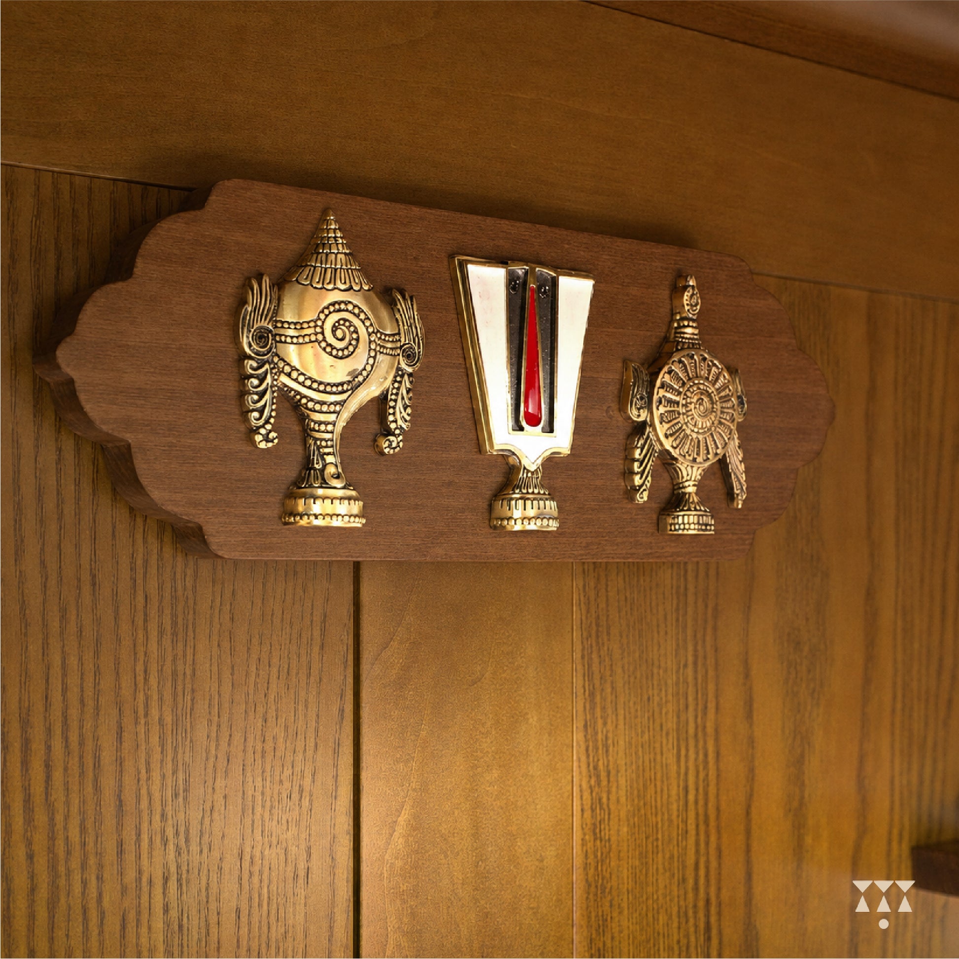 Decorative wooden panel with brass Shank chakra namaha on a wooden background