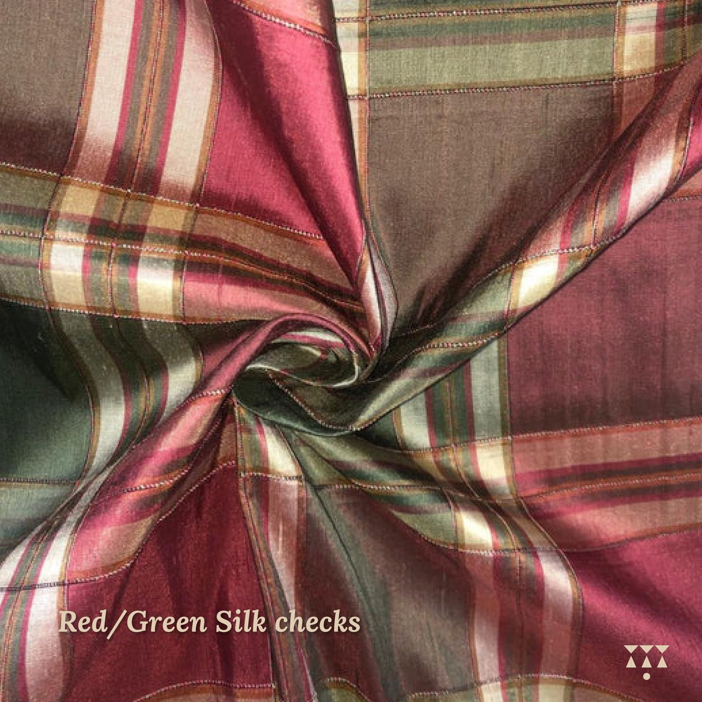 Close up of a red and green checked silk upholstery option for a solid wood wing chair