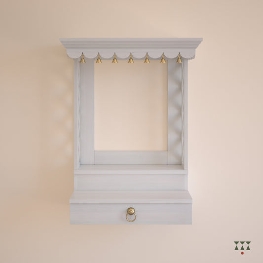 A wooden, wall mounted Mandir with clean lines, steps, storage and pure brass elements tinted in snow white