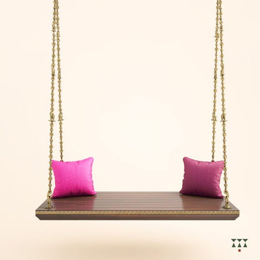 A solid wood swing base tinted in tamarind brown with decorative edging and brass chains with animal motifs and cushions